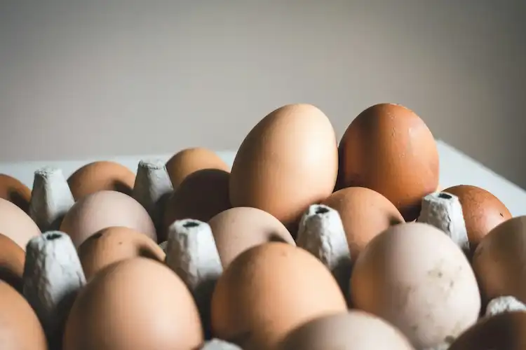 Batch of precisely cooked 7-minute eggs peeled and ready for meal prep, showing consistent yellow centers